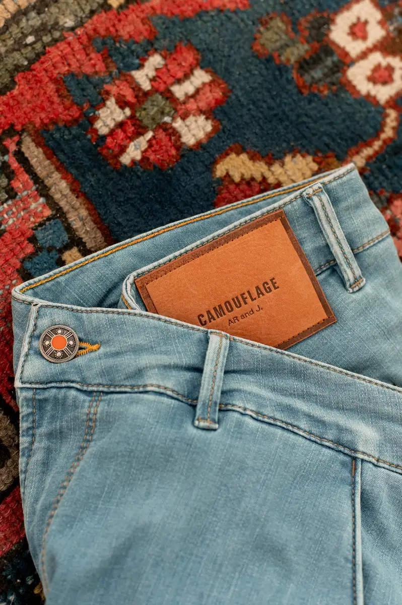 Close-up of Camouflage premium denim with branded leather patch detail