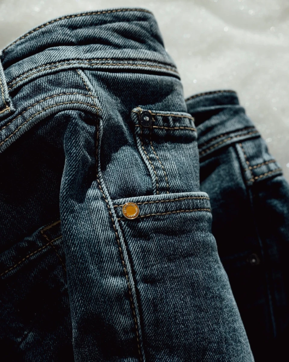 Close-up of Camouflage dark wash denim pocket and stitching detail