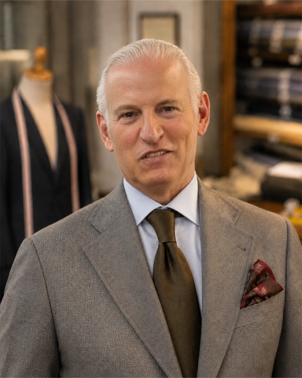 Image of a man, Umberto Dall'Agnese, posing with fabrics in the background.